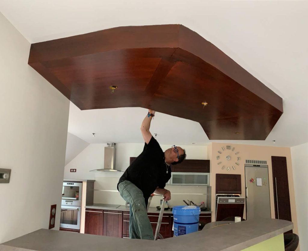 Homme travaille sur plafond en bois